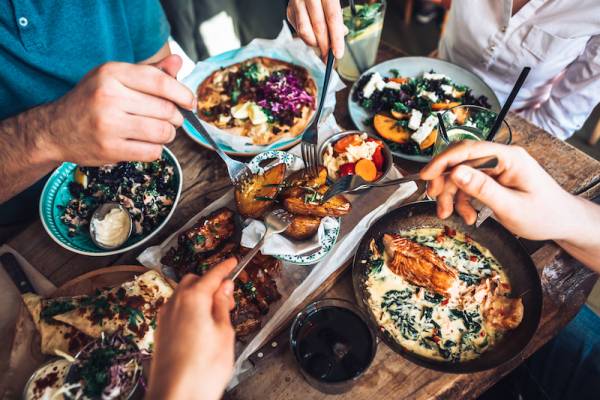 people gathered around a table full of food