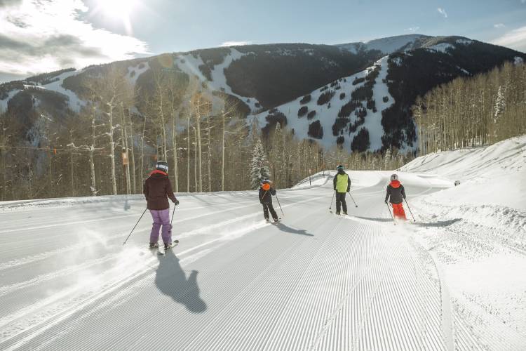 Family Skiing Freshly Groomed Cat Track at First Tracks