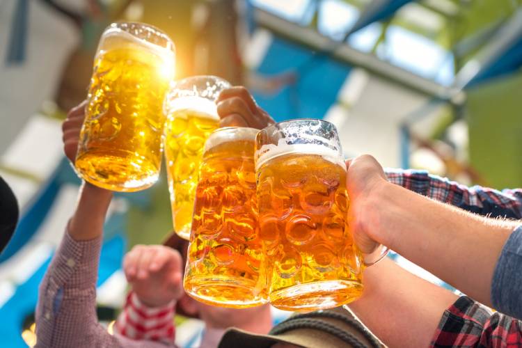 people hoisting beers at oktoberfest